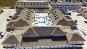 A large building with a central courtyard, multiple parking areas, and a pool. -  Village by the Beach!Townhome Walking distance to the BEACH, Heated Resort Pool (Corpus Christi)