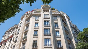 A multi-story building with a classical architectural style, featuring balconies and large windows.