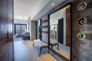 Un intérieur moderne avec un banc, un coin repas et une vue à travers une porte vitrée.