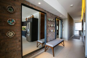Un intérieur moderne avec une cuisine, un banc et des assiettes décoratives accrochées au mur.