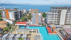 Un complexe hôtelier doté d’une piscine, de plusieurs bâtiments et offrant une vue sur l’océan.