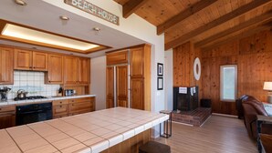 A kitchen with wooden cabinets, a tiled countertop, and a sign reading "BEACH HOUSE".