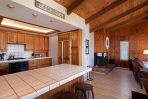 Una cucina con mobili in legno, un piano di lavoro piastrellato e un cartello con scritto 'BEACH HOUSE'.