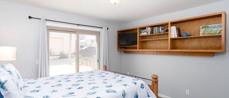 A bedroom with a bed, a bookshelf, a window, and a ceiling light.