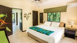 Une chambre à coucher comprenant un lit, des tables de chevet, une fenêtre avec vue, une porte et un élément de décoration murale.