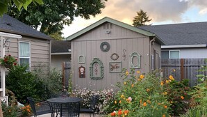 A residential backyard with a patio, decorative wall, and various plants.