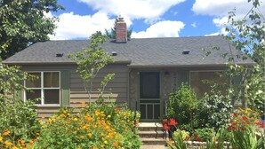 A two-story house with a chimney, a front door, and a small porch.