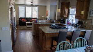 A spacious kitchen with wooden cabinets, a large island, and a dining area with chairs.