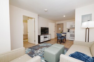 Un apartamento moderno con sala de estar, kitchenette y comedor.