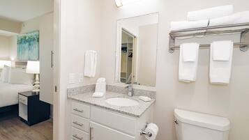 A hotel bathroom with a sink, toilet, and towel rack.