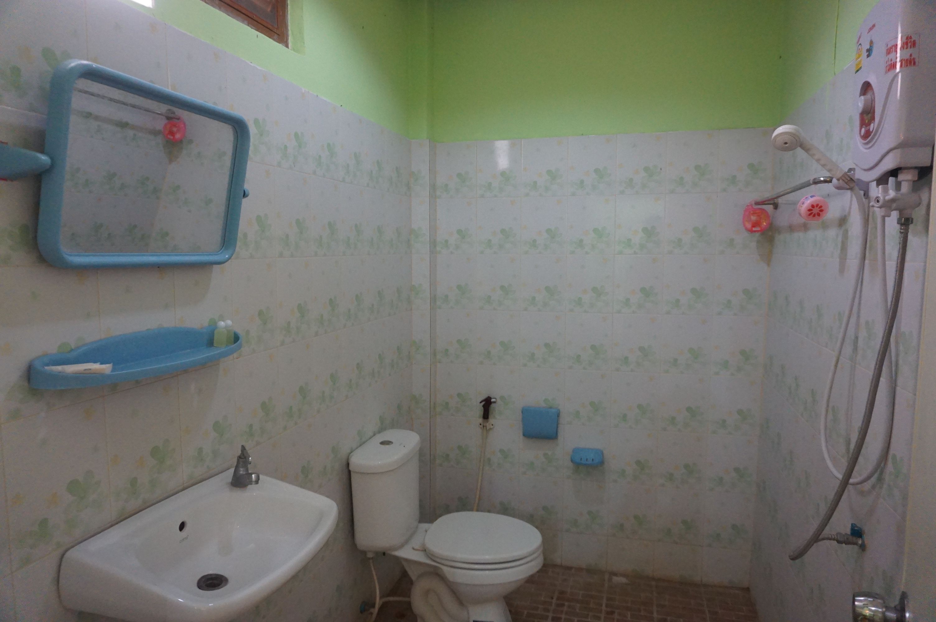 Un baño pequeño con inodoro, lavamanos y ducha.