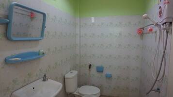 Un baño pequeño con inodoro, lavamanos y ducha.