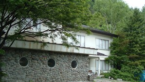 Un bâtiment à deux étages doté d’une façade en pierre et de fenêtres rondes.