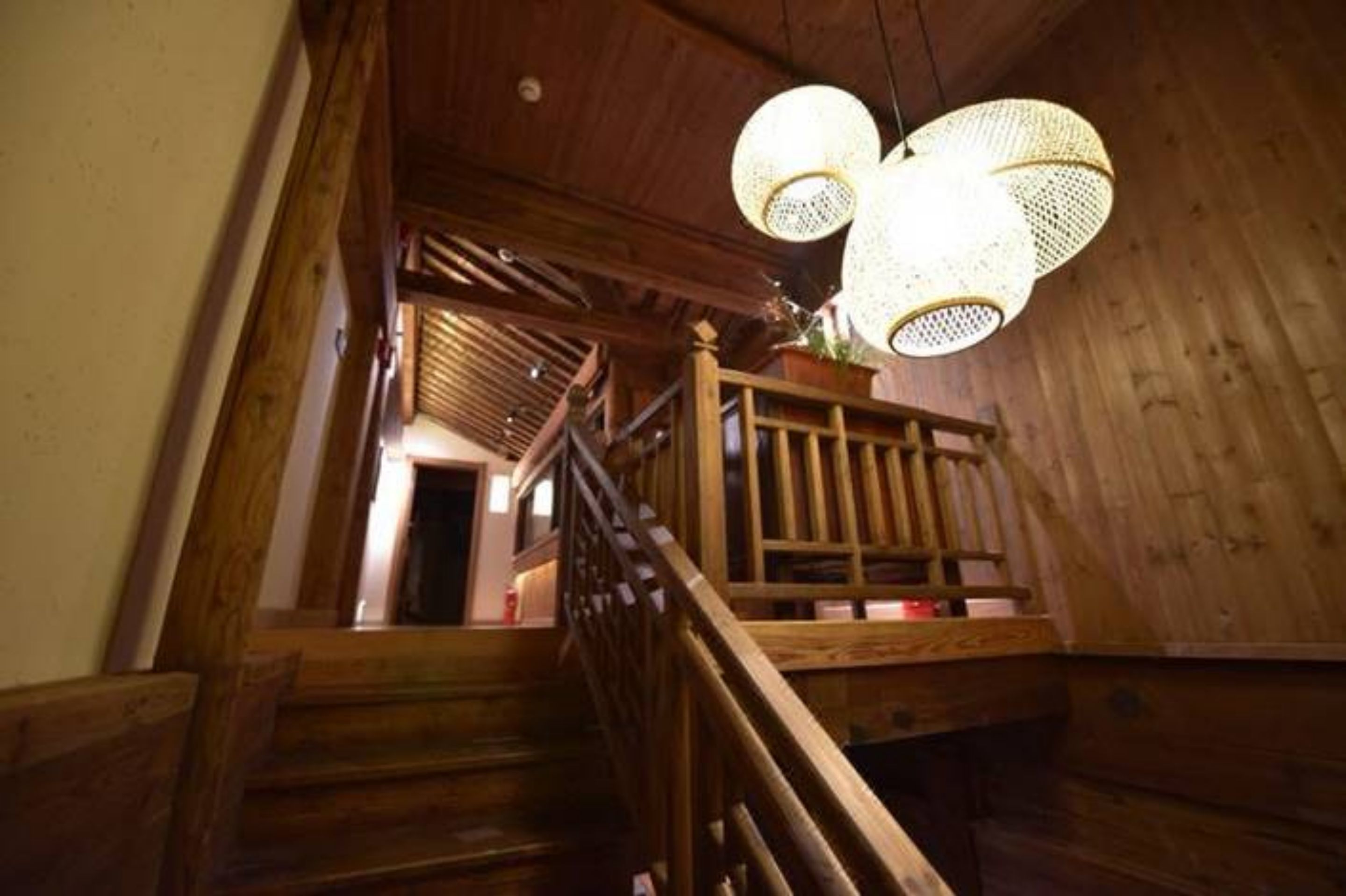 Una escalera de madera con barandilla que conduce a un nivel superior.