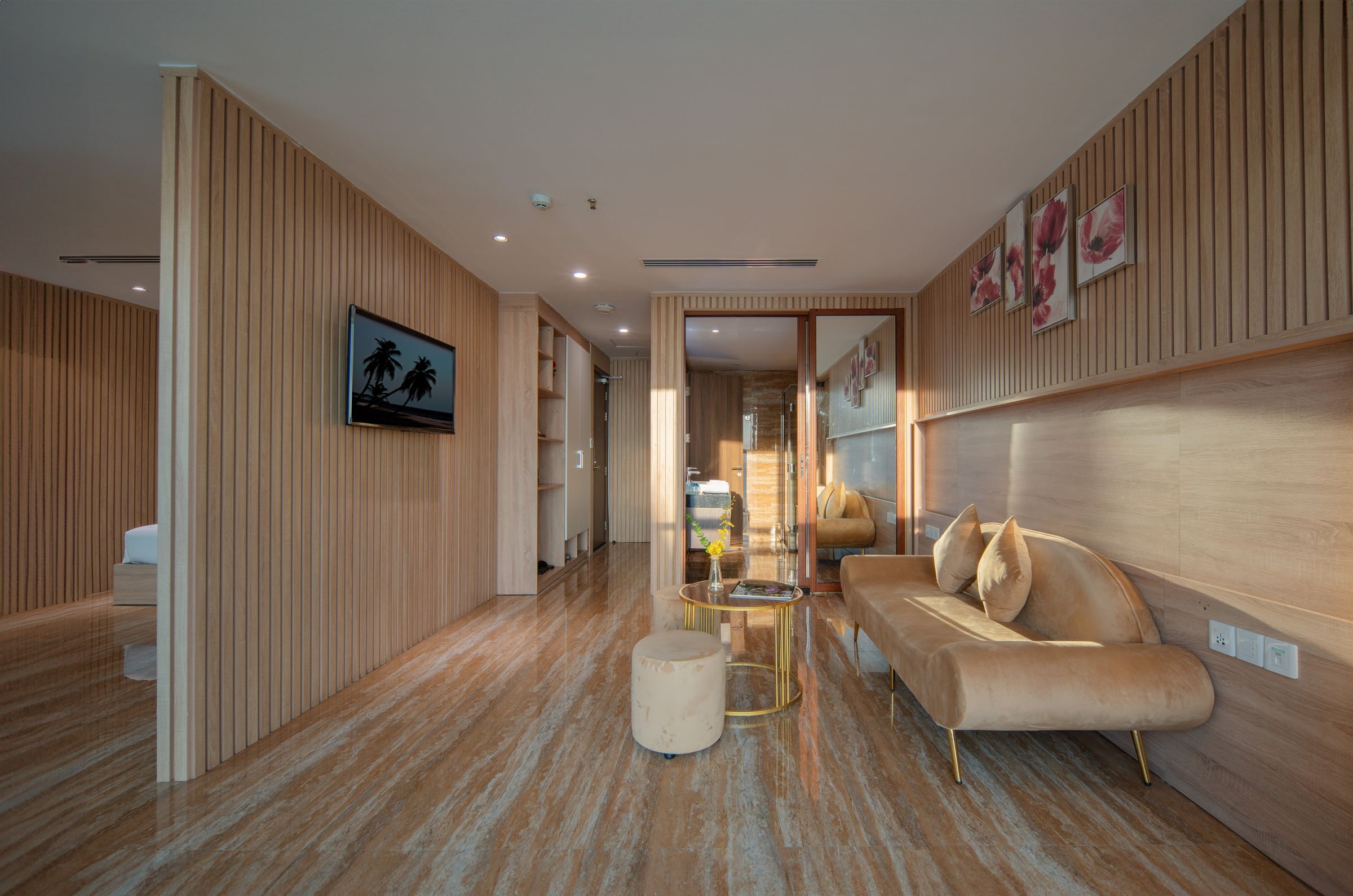 A modern interior with a wooden panel wall, a sofa, a round coffee table, and a framed picture on the wall.