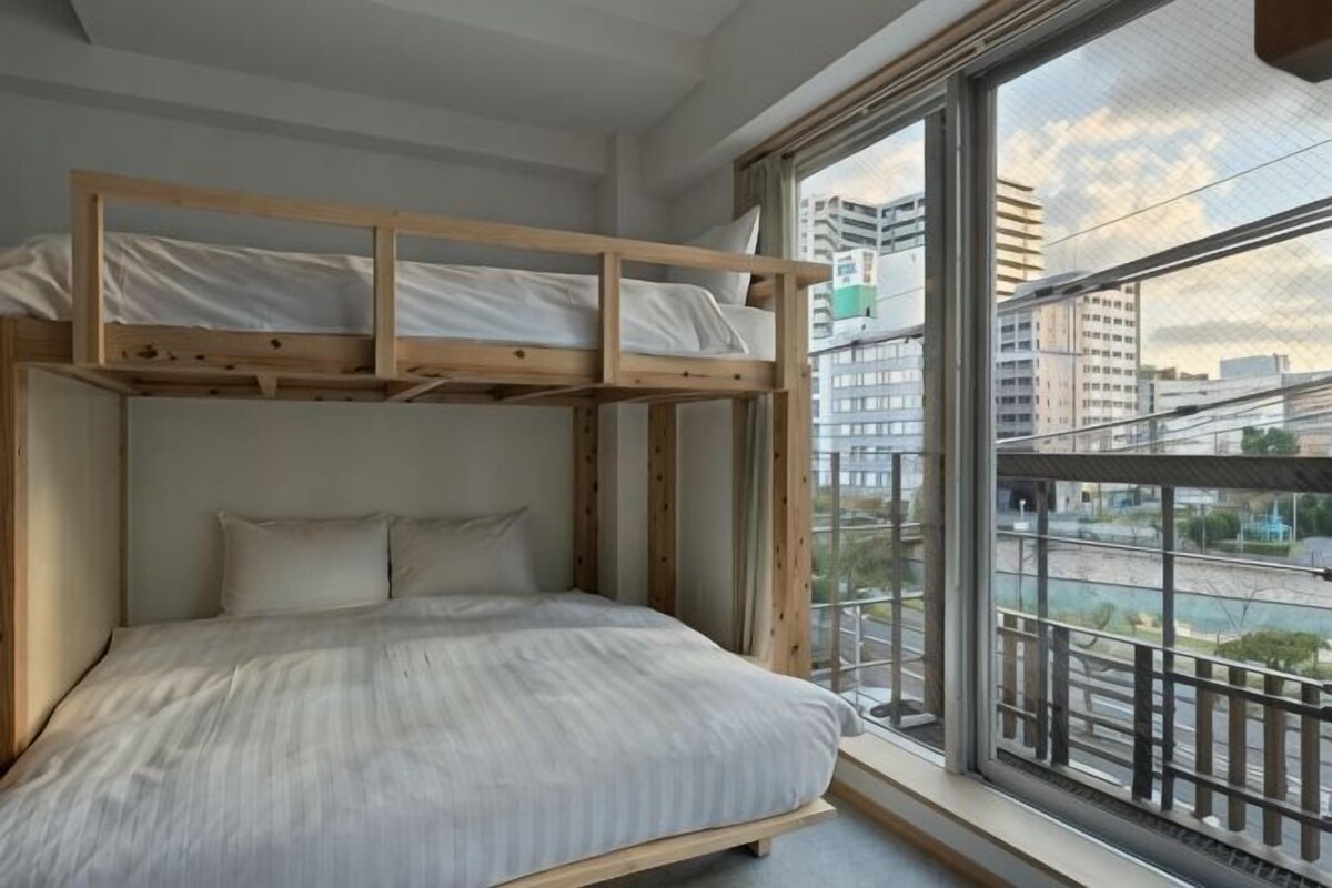 Un letto a castello con vista sulla città attraverso una grande finestra.