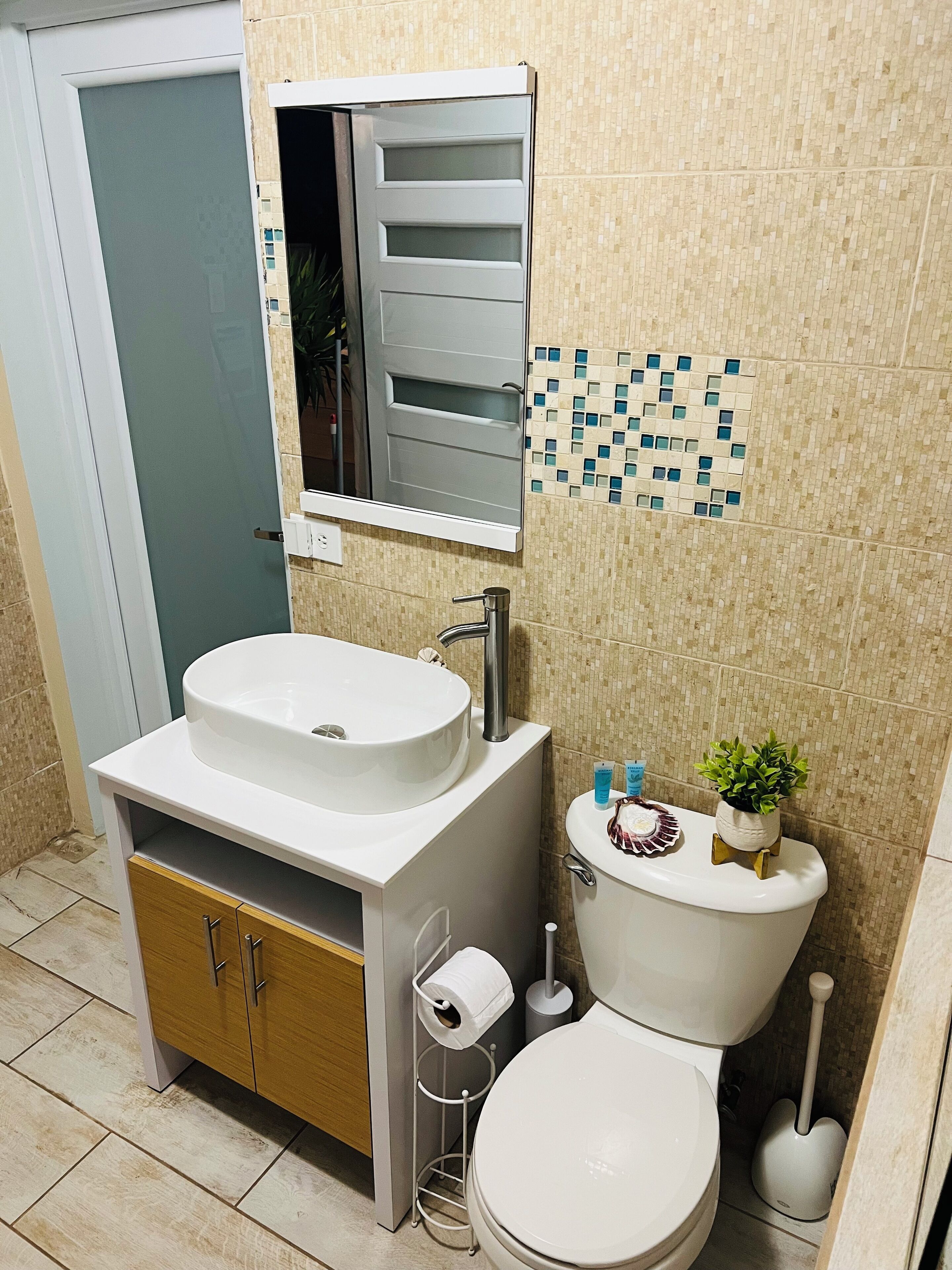A bathroom with a white sink, a toilet, and a mirror above the sink.