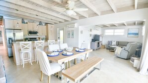 A spacious kitchen with a dining area, a large wooden table, and a ceiling fan. - WATERFRONT Key Colony Beach Retreat 37’ Dock Cabana Club- Kayak & Bikes- Parking (Marathon)
