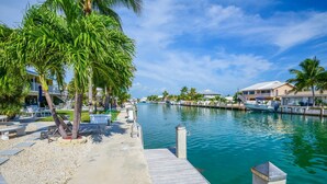 A waterfront property with a dock, palm trees, and a marina. - WATERFRONT Key Colony Beach Retreat 37’ Dock Cabana Club- Kayak & Bikes- Parking (Marathon)
