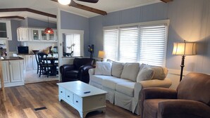 A living room with a sofa, armchair, coffee table, and a dining area with chairs and a table. - Close to Parris Island! Beaufort SC,  Newly Renovated 2 Bedroom 2 Bath Sleeps 6 (Beaufort)