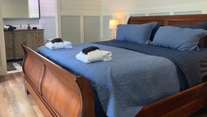 A double bed with a wooden headboard, two pillows, and a blue quilt. - Close to Parris Island! Beaufort SC,  Newly Renovated 2 Bedroom 2 Bath Sleeps 6 (Beaufort)