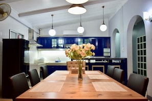 Enjoy meals in this kitchen with a dining table, pendant lights, and a large window.
