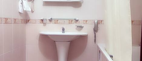 A bathroom with a toilet, sink, and shower curtain.
