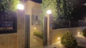 A nighttime entrance to a property with a sign reading "blue ark."