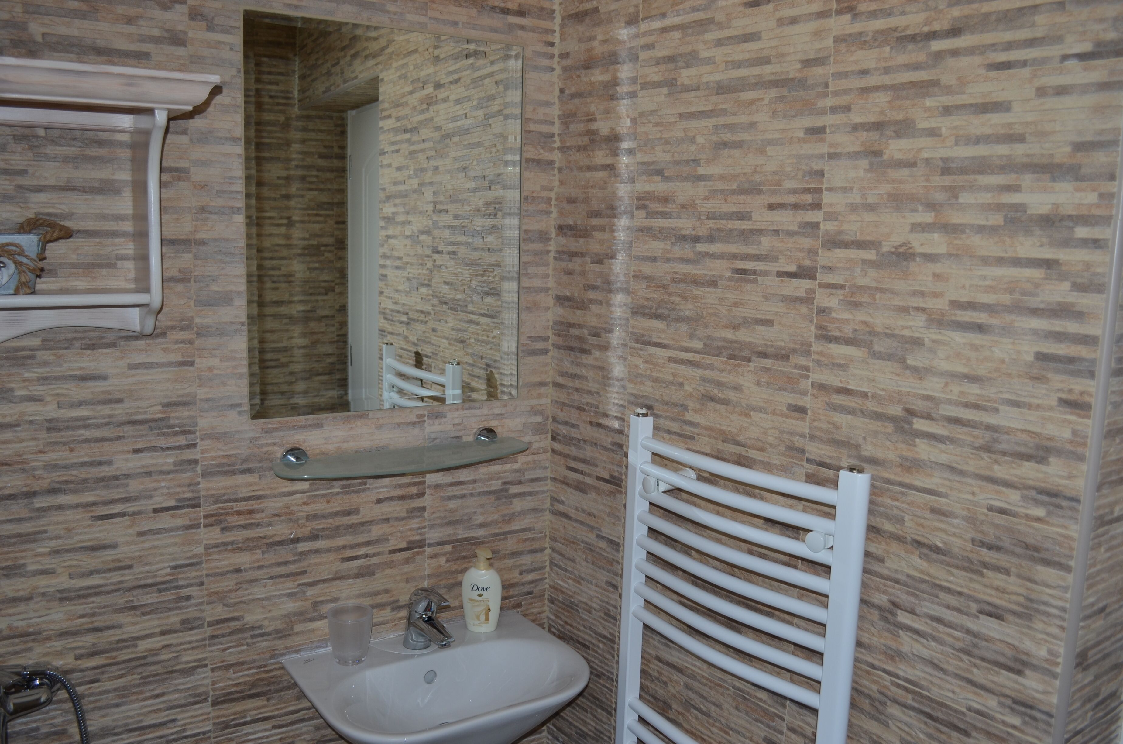 A bathroom with a sink, mirror, and towel rack.