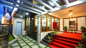 A hotel entrance with a red carpet, glass doors, and a sign for 'The Shack' restaurant. - Hotel The Shack (Bengaluru)