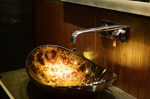 A bathroom with a glass bowl sink and a chrome faucet. - Maderla (Bangkok)