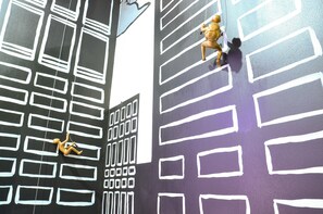 A stylized cityscape mural with abstract building patterns and a figure climbing a wall. - Maderla (Bangkok)