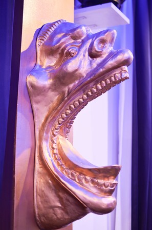 A metallic sculpture of a head with a prominent jaw and teeth. - Maderla (Bangkok)