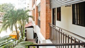 A residential building with a balcony, a parked motorcycle, and a palm tree. - RedDoorz Plus @ Mabolo Cebu (Cebu City)