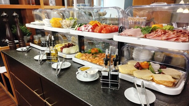 A buffet counter with various food items and condiments. - Hotel Schwert (Rastatt)