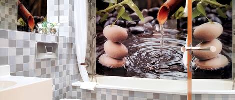 A bathroom with a modern design, featuring a toilet, sink, and a large mirror with a nature-themed artwork.