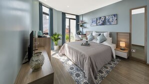 Une chambre moderne avec un grand lit, des tables de chevet, une télévision et une plante en pot.