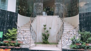 Un escalier orné de rampes en métal ouvragé, menant à un espace intérieur.