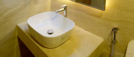 Un baño con un lavamanos blanco, un espejo y una ducha.