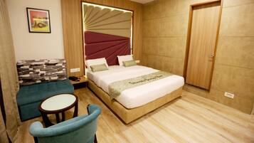 Una habitación de hotel moderna con una cama grande, un sofá, una mesita y una puerta.