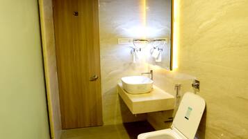 A compact bathroom with a wooden ceiling, a toilet, and a sink.