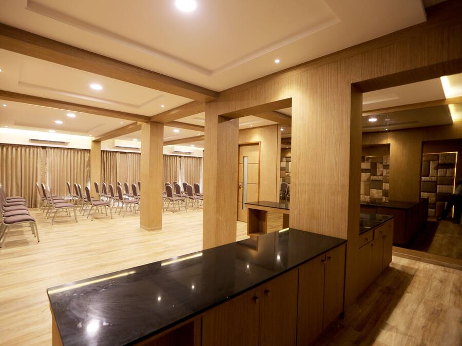 Un espacioso vestíbulo de hotel con un mostrador de recepción de madera, zona de estar y vistas al comedor.