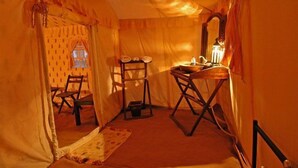 A tent-like room with a table, chairs, and a mirror. - A Plus Hospitalities (Phulpur)