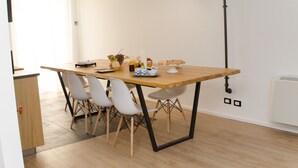 Ein stilvoller Essbereich mit einem Holztisch, weißen Stühlen und verschiedenen Speisen und Getränken.