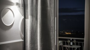 Ein Balkon mit einem Tisch für zwei Personen, einer Weinflasche und zwei Weingläsern.