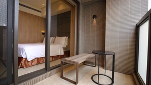 A modern hotel room with a bed, a bench, and a small table. - Kloud Hotel (Taichung)