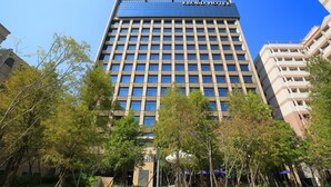 A modern hotel with a grid of windows, surrounded by trees and other buildings. - Kloud Hotel (Taichung)