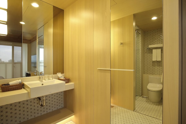 Un baño moderno con un espejo grande, dos lavamanos y una zona de ducha.
