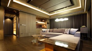 A modern living room with a sofa, coffee table, and a built-in bookshelf. - Kloud Hotel (Taichung)
