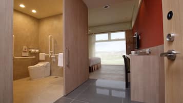A modern bathroom with a toilet, shower, and vanity.